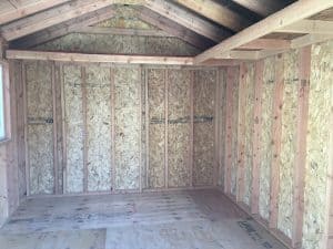 Wooden shed interior framing with OSB panels and roof structure.